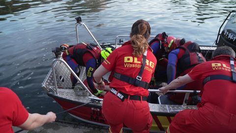 Bei einer Übung auf dem Neckar in Stuttgart versorgen mehrere Mitglieder der DLRG eine Person in einem Boot. 