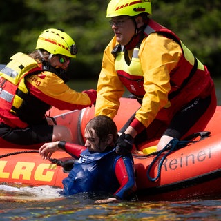 Mitglieder der Deutsche Lebens-Rettungs-Gesellschaft (DLRG) ziehen bei einer Übung im Neckar in Stuttgart einen Mann aus dem Wasser.