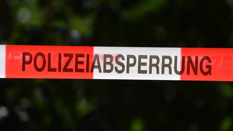 Ein Absperrband der Polizei sichert einen Tatort. In einem Wald bei Sindelfingen haben Arbeiter eine Frauenleiche entdeckt.