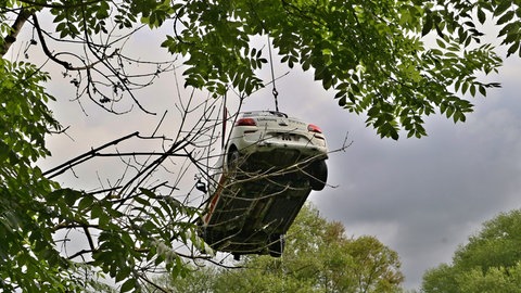 Aus dem Neckar geborgenes Auto wird von einem Kran in die Höhe gezogen