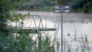 Ein Steg am Badesee in Plüderhausen mit einem Hinweisschild für Nichtschwimmer. Am Mittwochmorgen wurde eine Leiche im Badesee entdeckt. Es handele sich um einen 80-jährigen Mann, der seit vergangenem Sonntag vermisst wurde. (Symbolbild)