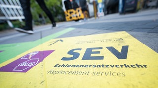 Ein Aufdruck auf dem Boden weißt auf Schienenersatzverkehr hin. Im Sommer 2025 müssen sich Pendler und Bahnreisende in und um Stuttgart auf viel Schienenersatzverkehr einstellen.