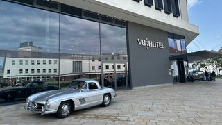 Vor dem V8 Hotel steht ein Mercedes Oldtimer. Das Hotel ist auf eine Betrugsmasche reingefallen. 