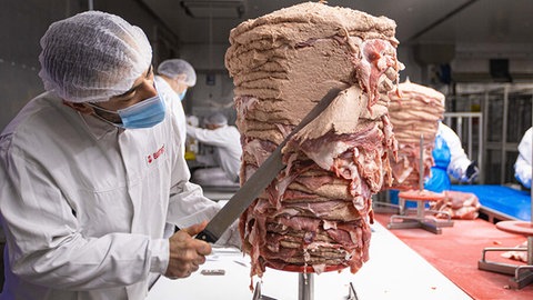 Bei Birtat wird das Fleisch zuerst vorbereitet und mariniert. Nach dem Aufstecken kommt der Feinschliff für die typische Kegelform.