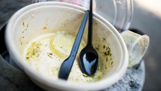 Ein Mülleimer ist bis oben voll mit Einwegverpackungen von einem Imbiss. Zwölf Unternehmen in Stuttgart aus Gastronomie und Handel kommen für die Reinigung der unteren Königstraße auf. 