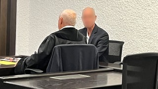 Ein Mann und ein Strafverteidiger bei Gericht. Vor dem Stuttgarter Landgericht muss sich ein 73-jähriger Mann aus Esslingen verantworten. Er soll seine Frau umgebracht haben.