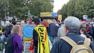 Hunderte Menschen sind zur 775. Montagsdemonstration auf den Schlossplatz in Stuttgart gekommen.  Die Kundgebung fand unter dem Motto "15 Jahre Schwarzer Donnerstag - Nix gelernt" statt.