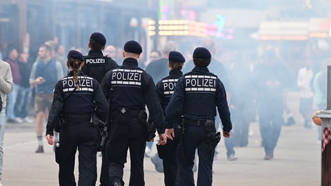 Polizisten laufen über das Gelände des Volksfests Cannstatter Volksfests. (Symbolbild)