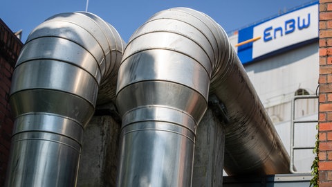Rohre sind am EnBW-Kraftwerk in Stuttgart-Münster vor dem Logo der EnBW zu sehen.