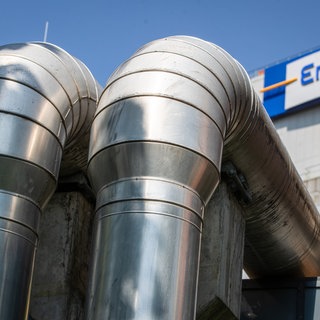 Rohre sind am EnBW-Kraftwerk in Stuttgart-Münster vor dem Logo der EnBW zu sehen.