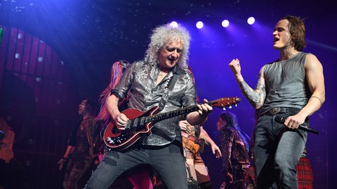 Queen-Gitarrist Sir Brian May steht mit seiner Gitarre neben dem Hauptdarsteller des Queen-Musicals Kasper Nilsson.