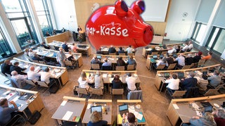 Ein großes rotes Sparschwein wurde eine Sitzung des Gemeinderats Stuttgarts montiert.