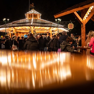 Besucher gehen über den Weihnachtsmarkt in Stuttgart.