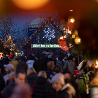 Besucher gehen über den Weihnachtsmarkt in Stuttgart 
