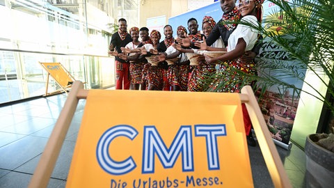 Eine Gruppe aus dem diesjährigen Partnerland Angola steht in traditioneller Bekleidung bei der Eröffnungspressekonferenz der Reisemesse CMT einen Tag vor Messebeginn in den Hallen der Landesmesse Stuttgart.
