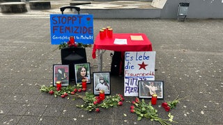 Kerzen, Blumen und Transparente bei der Gedenkkundgebung für die 31-jährige, getötete Pflegekraft in Stuttgart.