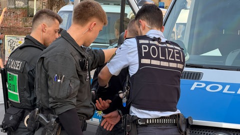 Polizisten nehmen am Samstag auf dem Marienplatz in Stuttgart nach einer Querdenken-Demonstration einen Gegendemonstranten fest. 