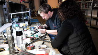 Konrad Walter in der Werkstadt in Kiew beim Bauen von Drohnen. Neben ihm die Eigentümerin der Drohnenfabrik Kseniia Kalmus.