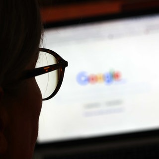 Eine Frau nutzt die Google-Suche auf einem Computer. (Archivbild)