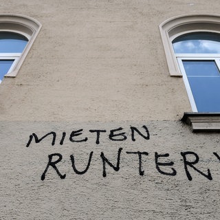 Der Schriftzug "Mieten runter!" ist an die Fassade eines Hauses geschrieben.