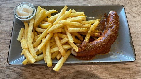 Eine Currywurst mit Pommes