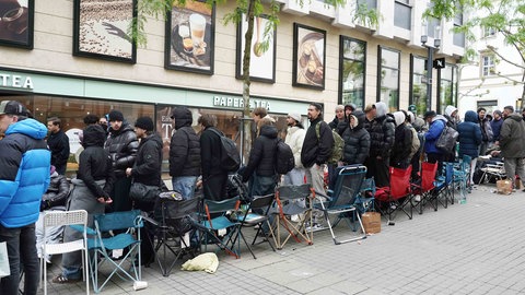 Junge Männer stehen in Stuttgart Schlange, um sich ein Exemplar einer neuen Swatch-Uhr zu kaufen.