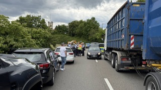 Eine Gruppe Polizisten steht auf der zweispurigen B10 in Stuttgart-Zuffenhausen zwischen stehenden Fahrzeugen.