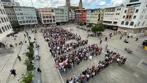 Menschen formen auf Demo großes Zeichen