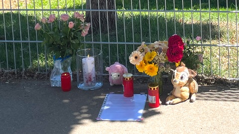 Blumen und Kerzen nahe der stelle, wo in einem Auto auf einem Parkplatz in Schorndorf am Mittwoch ein Kleinkind in einem Auto gestorben ist.