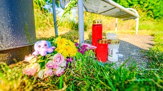 Kerzen und Blumen sind in der Nähe eines Bachlaufs bei Renningen abgelegt, wo die Leiche eines Babys entdeckt wurde. 