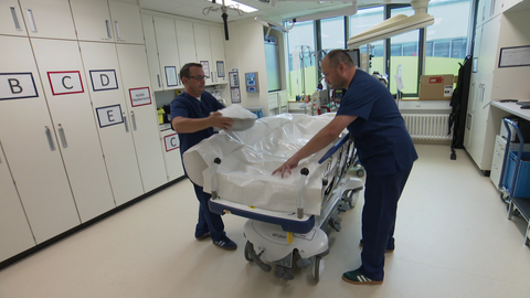 Ein Arzt der Notaufnahme befüllt einen Body Bag mit Eis um später einen Patienten zu kühlen.