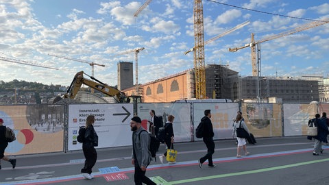 Menschen laufen von einmal um die Baustelle des Stuttgarter Hauptbahnhofs herum