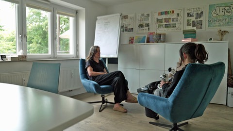 Zwei Frauen sitzen sich bei einem Einzelgespräch in der suchttherapeutischen Einrichtung JELLA gegenüber.
