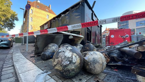 Bild einer Brandruine: Am frühen Freitagmorgen musste die Feuerwehr Stuttgart in Bad Cannstatt ausrücken, um einen brennenden Döner-Imbiss am Bahnhof zu löschen. Am Tag danach lagen die angekohlten Drehspieße noch auf der Straße.