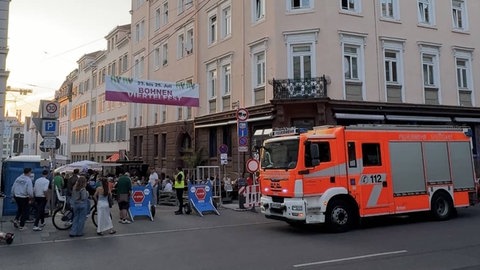 Feuerwehrauto vor einer belebten Gasse: Die Feuerwehr Stuttgart hatte in der Nacht auf Freitag beim Wohnungsbrand im Bohnenviertel die Herausforderung, dass parallel das Quartiersfest stattfand. 