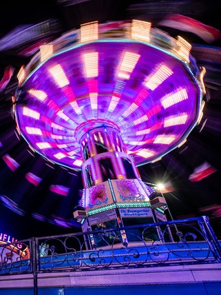 Das Kettenkarussell und Riesenrad auf dem Cannstatter Volksfest bei Nacht. Am 25. September startet das 179. Cannstatter Volksfest auf dem Wasengelände in Stuttgart.