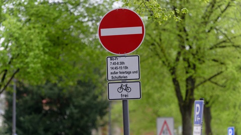 Ein Schild weist auf eine Sperrung einer Straße während der Bring- und Abholzeit einer in der Straße gelegenen Schule für den Autoverkehr. (Symbolbild)