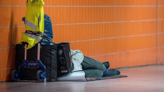 Ein Obdachloser schläft in einer Stuttgarter Unterführung (Archiv). Die Wohnungslosigkeit in Baden-Württemberg steigt.
