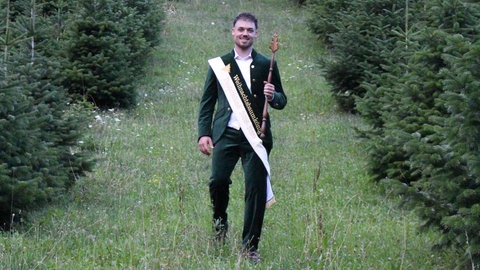 Der erste Weihnachtsbaumkönig Laurenz Vincent von Adelberg bei seinen Tannenbäumen.