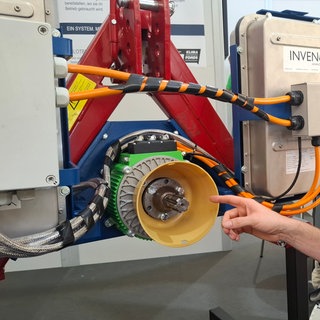 Philipp Seitz stellt im Messezelt auf dem Landwirtschaftlichen Hauptfest in Stuttgart den Prototypen des "AgriBoost" vor. Er soll den Traktor zu einem Hybrid machen und manche Landmaschinen vollelektrisch antreiben.