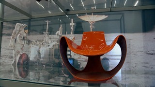 Ein futuristisch aussehender Stuhl in Orange.