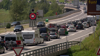 Autos stehen in den Schweizer Alpen auf der Autobahn im Stau.