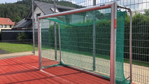 Ein Fußballtor vor einem Zaun, dahinter ein Haus - Anwohner klagen wegen abendlichen Lärms von Kindern und Jugendlichen.