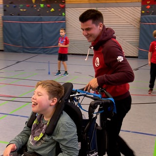 Yannick Adler in einer Sporthalle mit Kindern mit und ohne Behinderung