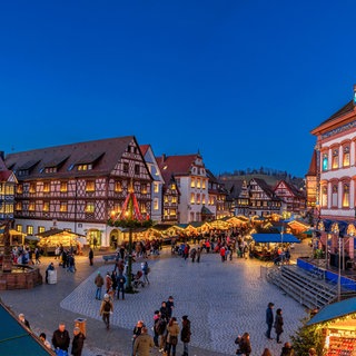 Der historische Adventskalender am Rathaus in Gengenbach. Drumherum stehen Weihnachtsmarkt-Buden. 