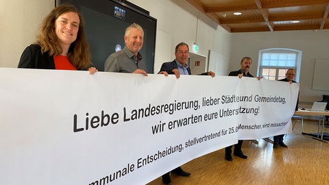 Bürgermeister aus der Region halten im Dezember 2024 ein Banner mit ihrer Forderung hoch. Es geht dabei um den Streit ums Stromnetz im Markgräflerland.