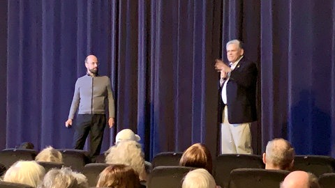 Kai Höss und Kinobetreiber Ludwig Ammann stehen nach dem Film auf der Bühne des Kinosaals zum Publikumsgespräch.