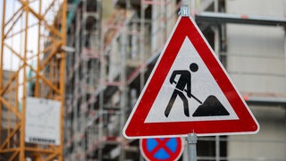 Ein großes Baustellenschild vor einem Gebäude