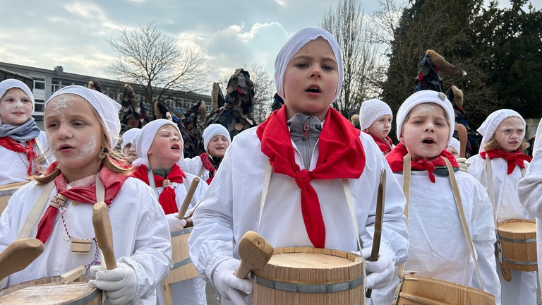 Einige Kinder ziehen als Geltentrommler durch die Stadt.