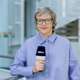 Porträtaufnahme von Ina Held mit Mikrofon in der Hand